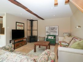 A living room with a television and a coffee table at Stable Cottage in Broadway
