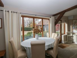 A dining room with a round table and chairs at Stable Cottage in Broadway