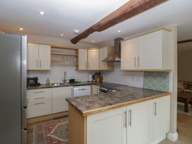 A kitchen with appliances and cabinetry at Stable Cottage in Broadway