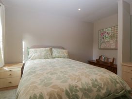 A bedroom with a bed and a painting at Stable Cottage in Broadway