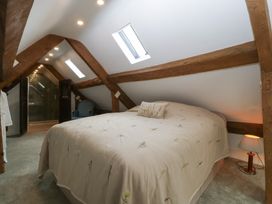 A bedroom with a bed and wooden beams at Stable Cottage in Broadway