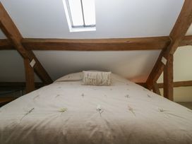 A bedroom featuring a bed with a pillow and skylight at Stable Cottage in Broadway