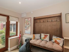 A seating area with a bench and window at Stable Cottage in Saintbury near Broadway