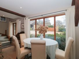 A dining room with a round table and chairs at Stable Cottage in Saintbury near Broadway