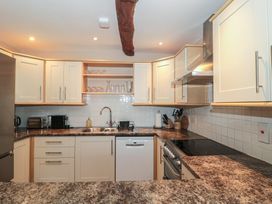 A kitchen with cabinets, sink, and appliances at Stable Cottage in Saintbury near Broadway