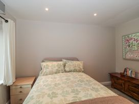 A bedroom with a bed and curtains at Stable Cottage in Saintbury near Broadway