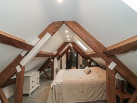 A bedroom with wooden beams and a bed at Stable Cottage in Saintbury near Broadway