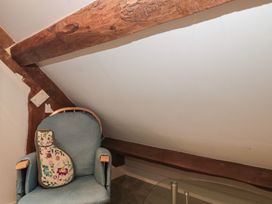 An attic with a chair and a cushion at Stable Cottage in Saintbury near Broadway