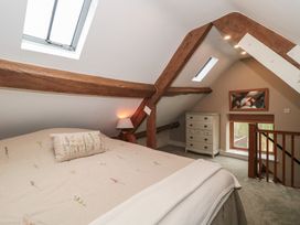 A bedroom with a bed and a dresser at Stable Cottage in Saintbury near Broadway