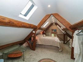 A bedroom with a bed and table at Stable Cottage in Saintbury near Broadway