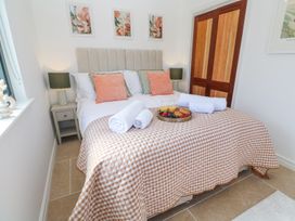 A bedroom with a bed with a checkered bedspread cushions towels and breakfast tray at Little Victory in Pendeen