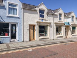 A street view of small commercial buildings with display windows and doors at Medical Hall in Cemaes Bay