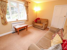 A living room with two sofas a wooden coffee table and floral curtains at Maiden Moor in Grange near Keswick