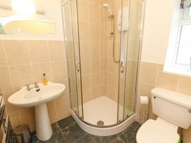 A bathroom with a shower enclosure a pedestal sink and a toilet at Maiden Moor in Grange near Keswick