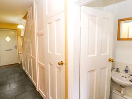A hallway with multiple white doors a staircase and a sink visible behind one door at Maiden Moor in Grange near Keswick