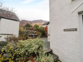 An outdoor area with a picnic table stone wall plants and a mountain in the background at Maiden Moor in Grange near Keswick