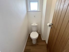 A small bathroom with a toilet a wooden door and a window at War Horse Valley Orchard View in Hatherleigh