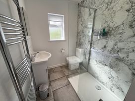 A bathroom with a sink toilet and walk in shower with marble walls at War Horse Valley Orchard View in Hatherleigh