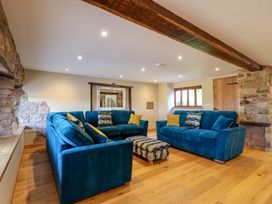 A living room with blue sofas and a wooden beam at Heathmoor in Horrabridge