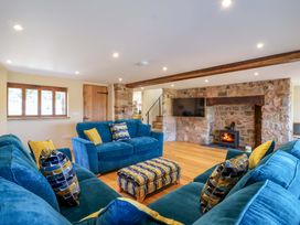 A living room with blue sofas and a fireplace at Heathmoor in Horrabridge