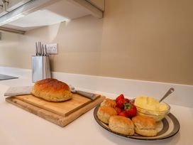 A kitchen with bread, strawberries, and butter on a plate at Heathmoor in Horrabridge