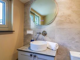 A bathroom with a sink, mirror, and towel at Heathmoor in Horrabridge