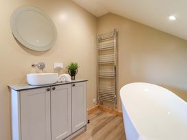 A bathroom featuring a bathtub, sink, and towel warmer at Heathmoor in Horrabridge