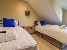 A bedroom with two beds and a wooden shelf at Heathmoor in Horrabridge