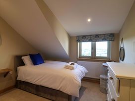 A bedroom with a bed and windows at Heathmoor in Horrabridge