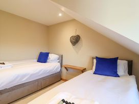 A bedroom with two single beds and a wooden table at Heathmoor in Horrabridge