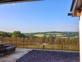 A garden view with a fence and seating area at Heathmoor in Horrabridge