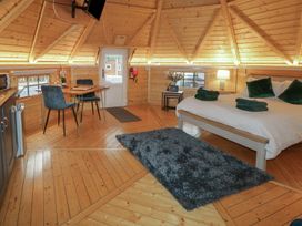 A wooden interior room with a bed table and chairs a rug and a door at The Hideaway in Dungiven Londonderry