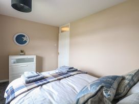 A bedroom with a bed with pillows and folded towels a white chest of drawers and a door at White Lion Retreat in Cromer