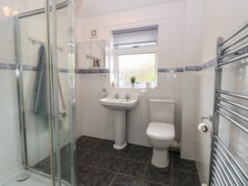 A bathroom with a shower, sink, toilet, mirrored cabinet, and towel radiator at White Lion Retreat in Cromer