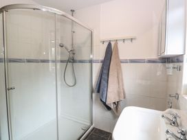 A bathroom with a glass shower enclosure two towels hanging and a white sink at White Lion Retreat in Cromer