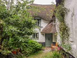 A garden with a thatched roof cottage at 3 Cumberland Cottages Ringmore