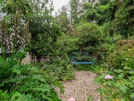 A garden with a bench surrounded by plants at 3 Cumberland Cottages in Ringmore
