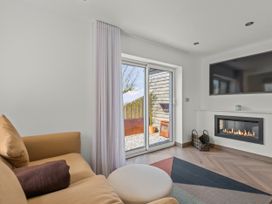 A snug with a sofa, television, and fireplace at Capton Snug in Capton near Dartmouth