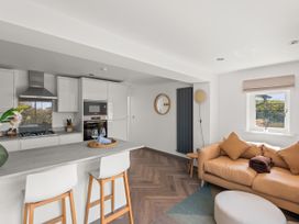 A kitchen with a sofa and dining area at Capton Snug near Dartmouth