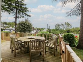 An outdoor space with a wooden table and chairs at Fir Grove Menai Bridge