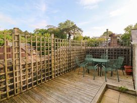 An outdoor patio area with a table and chairs at The Fir Grove Annex in Menai Bridge