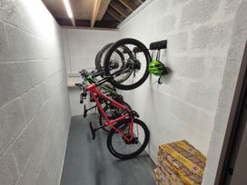 A storage room with bicycles mounted on the wall at Bramble Cottage Thornthwaite near Braithwaite