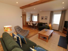 A living room with a sofa and dining area at Bramble Cottage Thornthwaite near Braithwaite