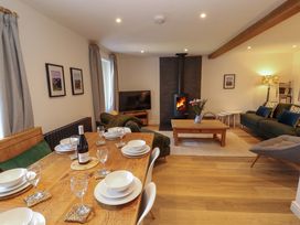 A living room with a dining area and fireplace at Bramble Cottage Thornthwaite near Braithwaite