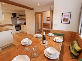 A dining area with table and wine bottles at Bramble Cottage Thornthwaite near Braithwaite