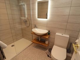 A bathroom with a shower, sink, and toilet at Bramble Cottage in Thornthwaite near Braithwaite