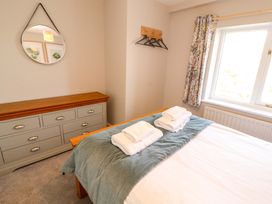 A bedroom with a bed, dresser, and mirror at Bramble Cottage Thornthwaite near Braithwaite