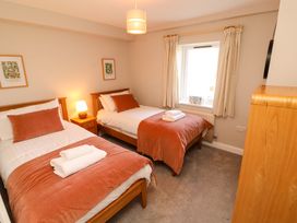 A bedroom with two beds and a window at Bramble Cottage Thornthwaite near Braithwaite