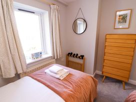 A bedroom with a bed and window at Bramble Cottage in Thornthwaite near Braithwaite