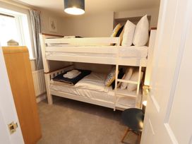 A bedroom with bunk beds and a wardrobe at Bramble Cottage Thornthwaite near Braithwaite